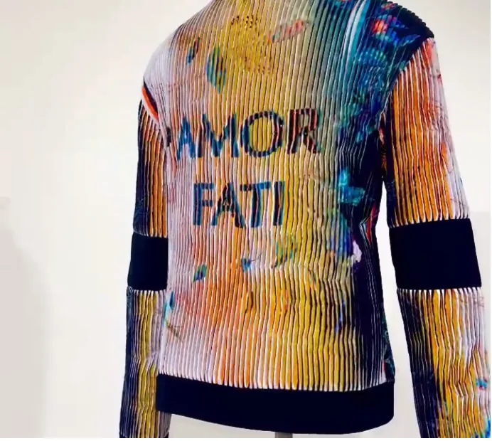 Lenticular jacket reading Amor Fati in pale, bright color.